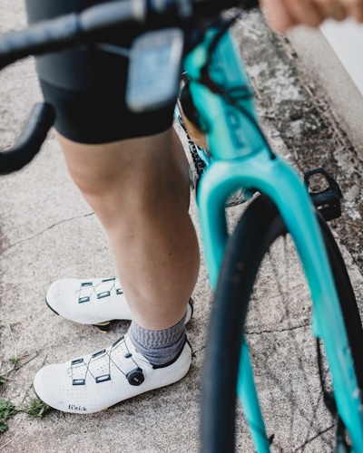 Person in white nike sneakers riding a cycle