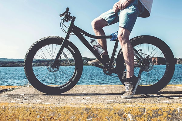 man riding a fat tire bike by the lake